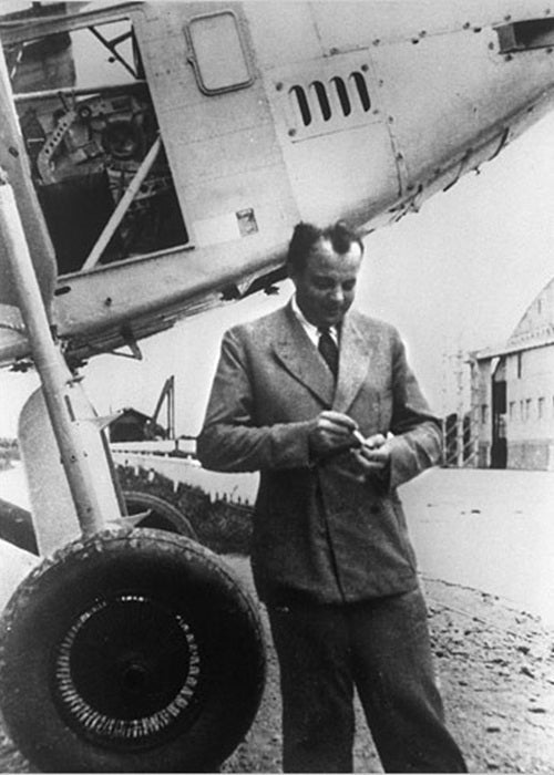 schwarz-weiß Fotografie von Antoine de Saint-Exupéry vor einem Flugzeug